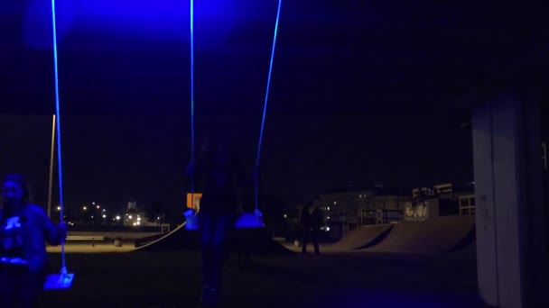 Kvinna gunga på neon ljus glödande swing på natten. 4k — Stockvideo