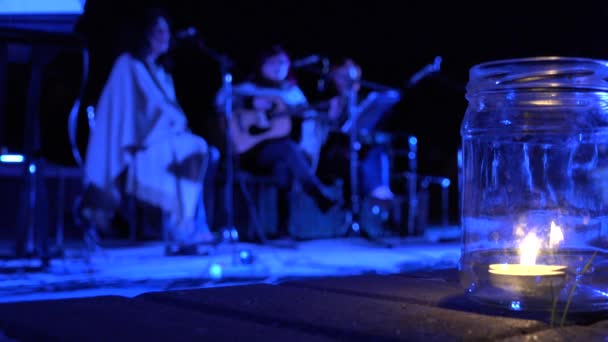 Svíčka hoří a dámy ženy hrát na kytaru a zpívat poezie v noci. 4k — Stock video