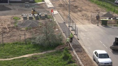 İşçi takımı kaldırım kaldırımlarını yolun yakınına döşedi. 4K