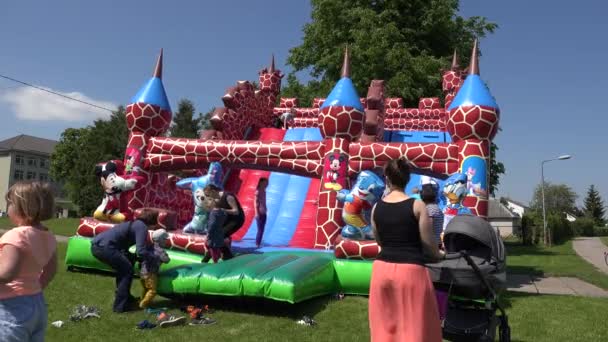 Niños niños juegan en el castillo inflable del juguete del patio. 4K — Vídeos de Stock