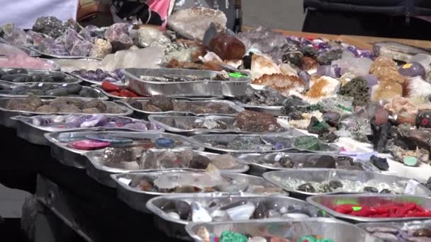 Hombre vender variedad de piedras astrológicas de colores en el mercado de la ciudad. 4K — Vídeo de stock
