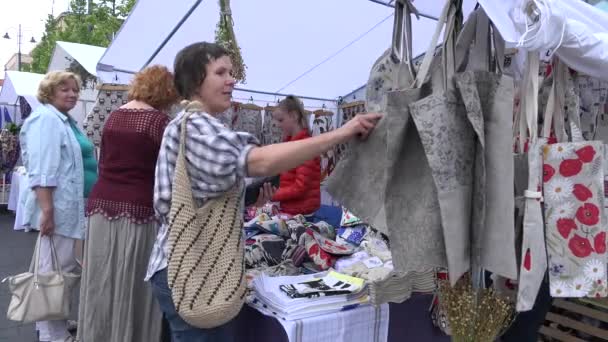 Kvinnor väljer shopping väska tillverkad av linne på stadens marknad. 4K — Stockvideo