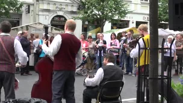 Folk musician entertain people and girls on swing at city street fair. 4K — Stock Video