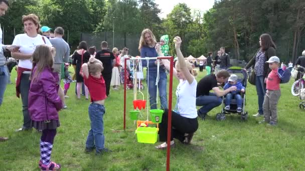 Orgulloso niño lanzar bola en cubo de juguete cuelgan de la cuerda. 4K — Vídeos de Stock