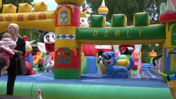 Дети веселятся на надувной взрывной площадке для игрушек. 4K — стоковое видео