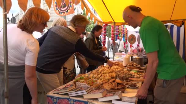 Touriste et citoyen achètent des bonbons et des produits avec de la viande dans la boulangerie. 4K — Video