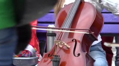 kız müzisyen viyolonsel üçlüsü ve solist insanlar için sokakta şarkı. 4k
