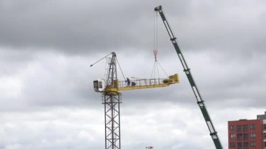 İnşaatçılar bulutlu gökyüzü arka plan üzerinde vinç monte. 4k
