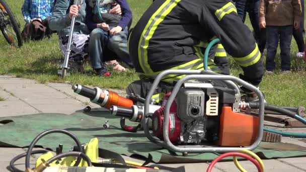 Спасатели демонстрируют оборудование возле пожарного грузовика. 4K — стоковое видео