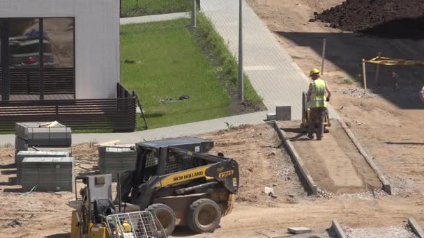 Arbeiter Druck Sand für Fliesen Bürgersteig mit Plattenverdichter. 4K — Stockvideo