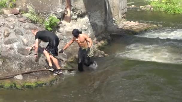 Persone guadare torrente fiume e muscoloso atleta ninja. 4K — Video Stock