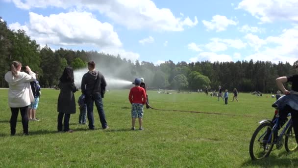 Brandweerman spray van water slang en mensen publiek. 4k — Stockvideo