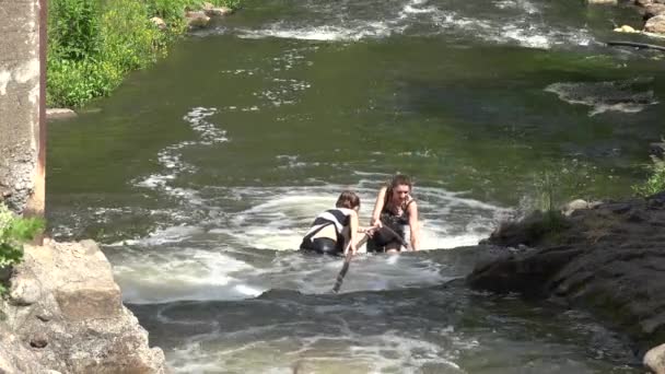 Εμπόδιο κούρσα κορίτσι αναρρίχηση με σχοινί μέσα από το ποτάμι βραχώδης ροής. 4K — Αρχείο Βίντεο