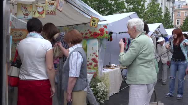 Turistas y ciudadanos compran recuerdos en el mercado callejero. 4K — Vídeo de stock