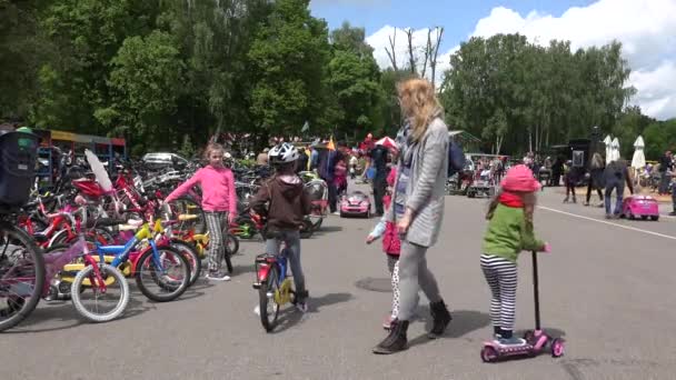 Los niños conducen bicicleta scooter y coche de juguete eléctrico. 4K — Vídeos de Stock