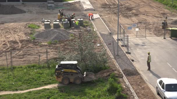 Zespół pracowników zrobić płytki nawierzchni chodnika w pobliżu nowych domów płaski. 4k — Wideo stockowe