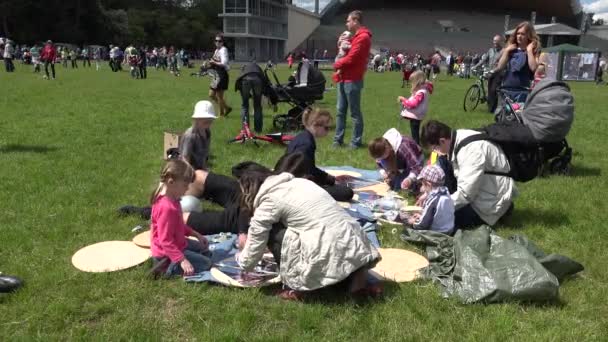 Los padres con niños construyen cometas en el prado del parque. 4K — Vídeo de stock