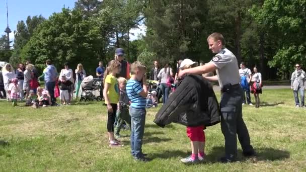 Glückliche Kinder messen Kleidungsstücke, die für Polizeihundeübungen verwendet werden. 4k — Stockvideo