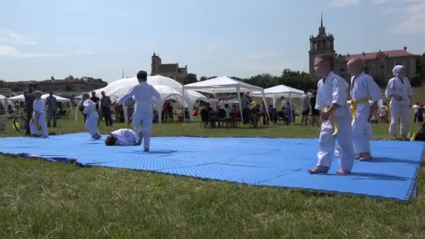 Kinder machen Purzelbäume, indem sie auf einem Teppich liegen. 4k — Stockvideo