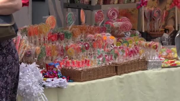 Doces coloridos vendidos na feira de rua da cidade e pessoas com crianças. 4K — Vídeo de Stock