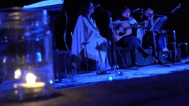 Concerto de poesia por trio de mulheres na vida noturna da cidade com luz de velas. 4K — Vídeo de Stock