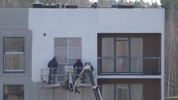 Bauarbeiter streichen neu errichtete moderne Flachhauswände in Weiß an. 4k — Stockvideo