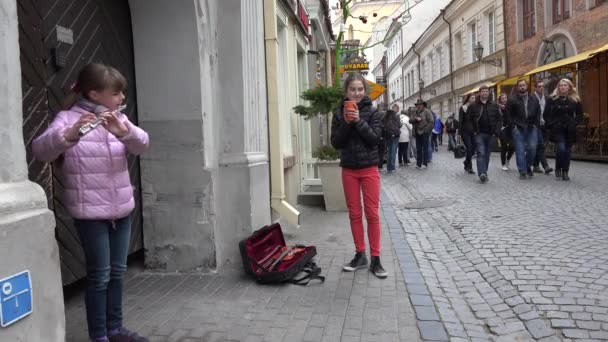 Menina jogar com flauta fife pipe no evento de rua as pessoas ignoram. 4K — Vídeo de Stock