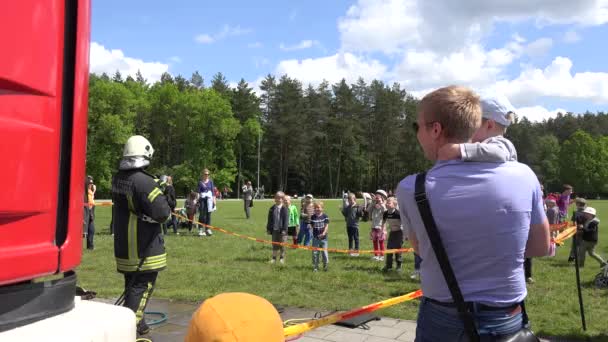 Niños felices refrescarse bajo el agua de la manguera bombero. 4K — Vídeos de Stock