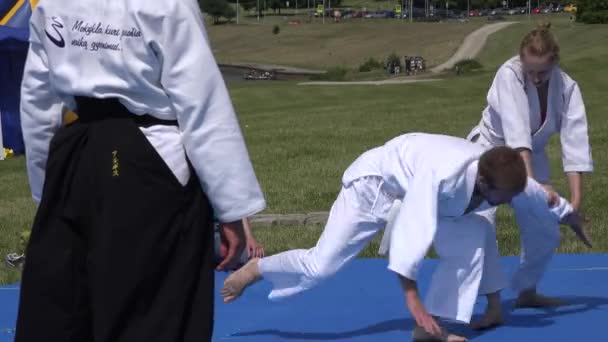 Woman and man demonstrate fighting art Aikido on mat outdoor . 4K — Stock Video