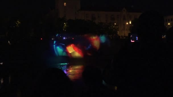 Man with smartphone shoot video light projections over river at nigh. 4K — Stock Video