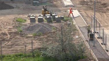 İşçi basınçlı moloz plaka sıkıştırıcı ve kaldırıma serili fayanslar. 4K