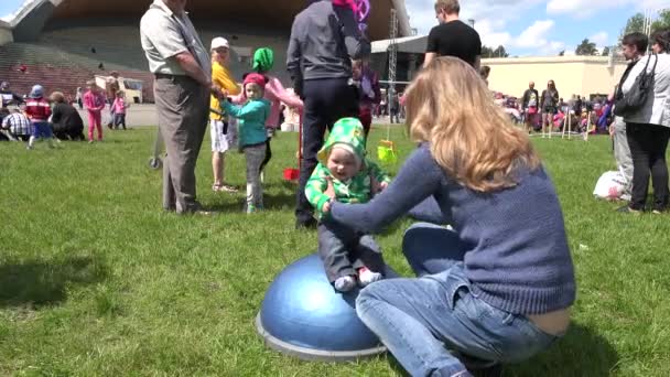 Mãe mulher com pequena filha bebê se divertir em pequeno trampolim. 4K — Vídeo de Stock