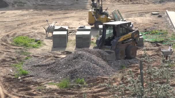 Pekerja dengan muatan traktor khusus puing-puing ke sendok dekat tumpukan ubin. 4K — Stok Video