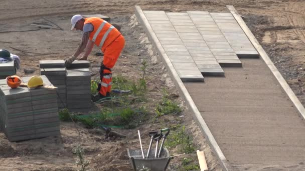 Werknemer dragen en leggen tegels op nieuwe stoep stoep. 4K — Stockvideo