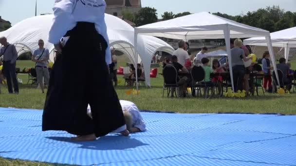 Martial trainer laikus gyermekek szőnyeg és a lány ugrik át őket. 4k — Stock videók