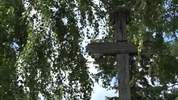 Cruz de madeira retro entre ramos de bétula em movimento. 4K — Vídeo de Stock