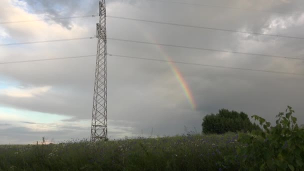 Cielo nublado con arco iris cerca del poste de electricidad. 4K — Vídeos de Stock