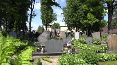 Acılı kadın mezarlıkta baba koca mezar yakınında küçültmek. 4k