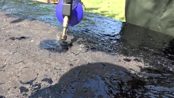 Worker man hands repair lay tar on roof surface with special tools. 4K — Stock video