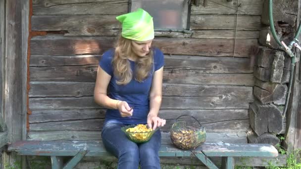 Gardener woman with knife clean chanterelle mushrooms on bench. 4K — Stock Video