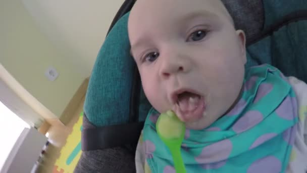 Close-up vijf maanden oude Kaukasische baby meisje of jongen lepel gevoed. 4k — Stockvideo