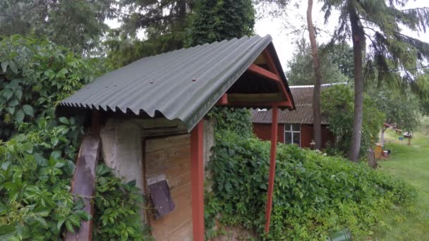 Casas de aldeia de madeira e gotas de chuva caem do telhado. 4K — Vídeo de Stock