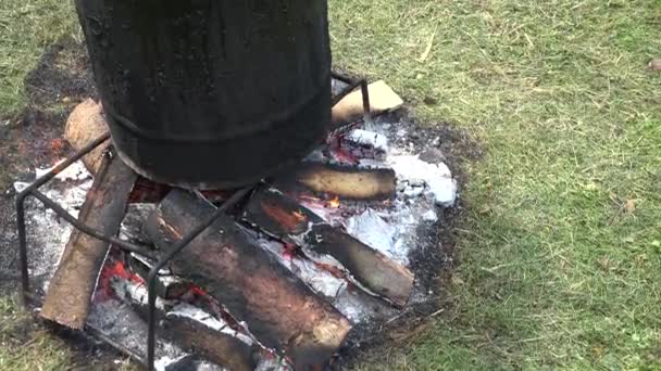 Βαρέλι στάση σε φωτιά και ψαράς επισκευή ξύλινη βάρκα με λιωμένο πίσσα. 4k — Αρχείο Βίντεο
