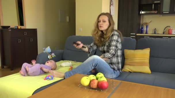Madre niñera ver la televisión con el bebé. 4K — Vídeo de stock
