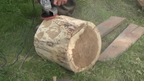 Obrero creativo mano de hombre con herramienta lijadora eléctrica corteza de tronco de árbol de arena. Primer plano. 4K — Vídeos de Stock