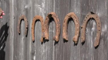 Retro paslı at ayakkabısı el eski ahşap kırsal ev duvar sarkan. Closeup. 4k