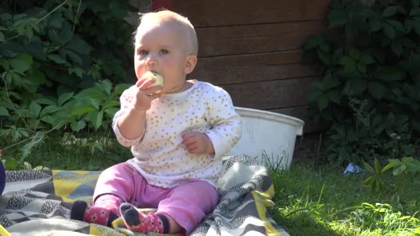 Niño adorable comiendo fruta de manzana en el jardín rural. 4K — Vídeos de Stock