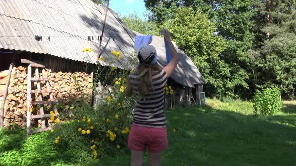 Villager žena, která si pověsila dětské oblečení na strunu v blízkosti venkovského domu. 4k — Stock video