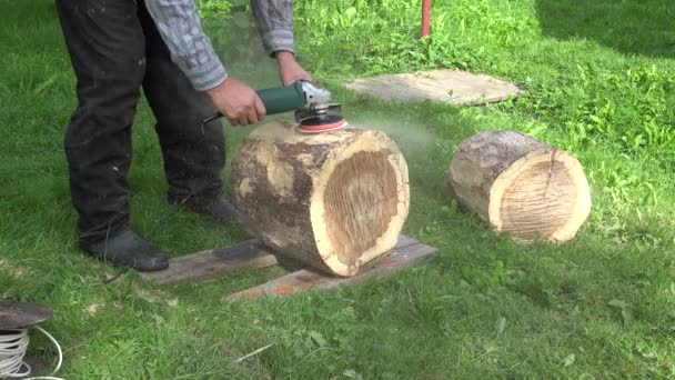 Man hand med elektrisk slipmaskin verktyg sand trä Oak Tree log. Närbild. 4K — Stockvideo