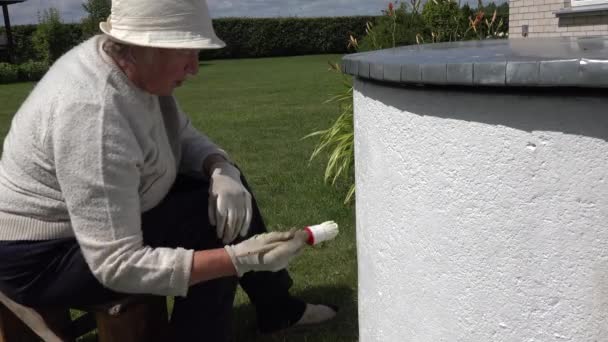 Pensionista mujer con pincel pintar bien casa en color blanco. 4K — Vídeos de Stock